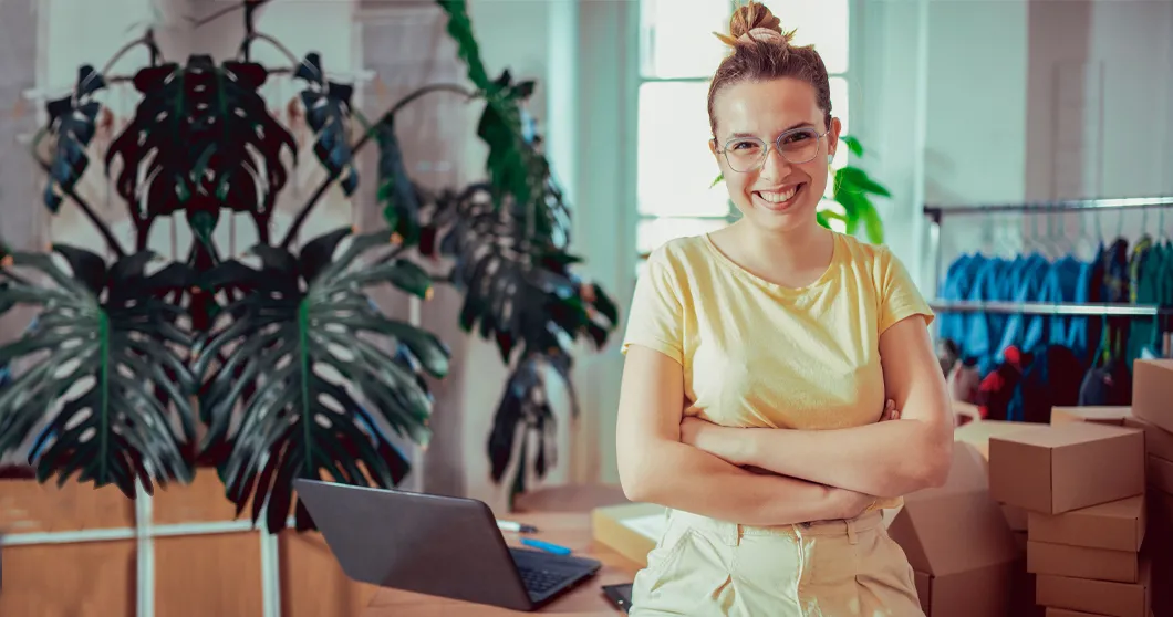 Jonge, lachende eigenaar van een klein bedrijf op haar kantoor